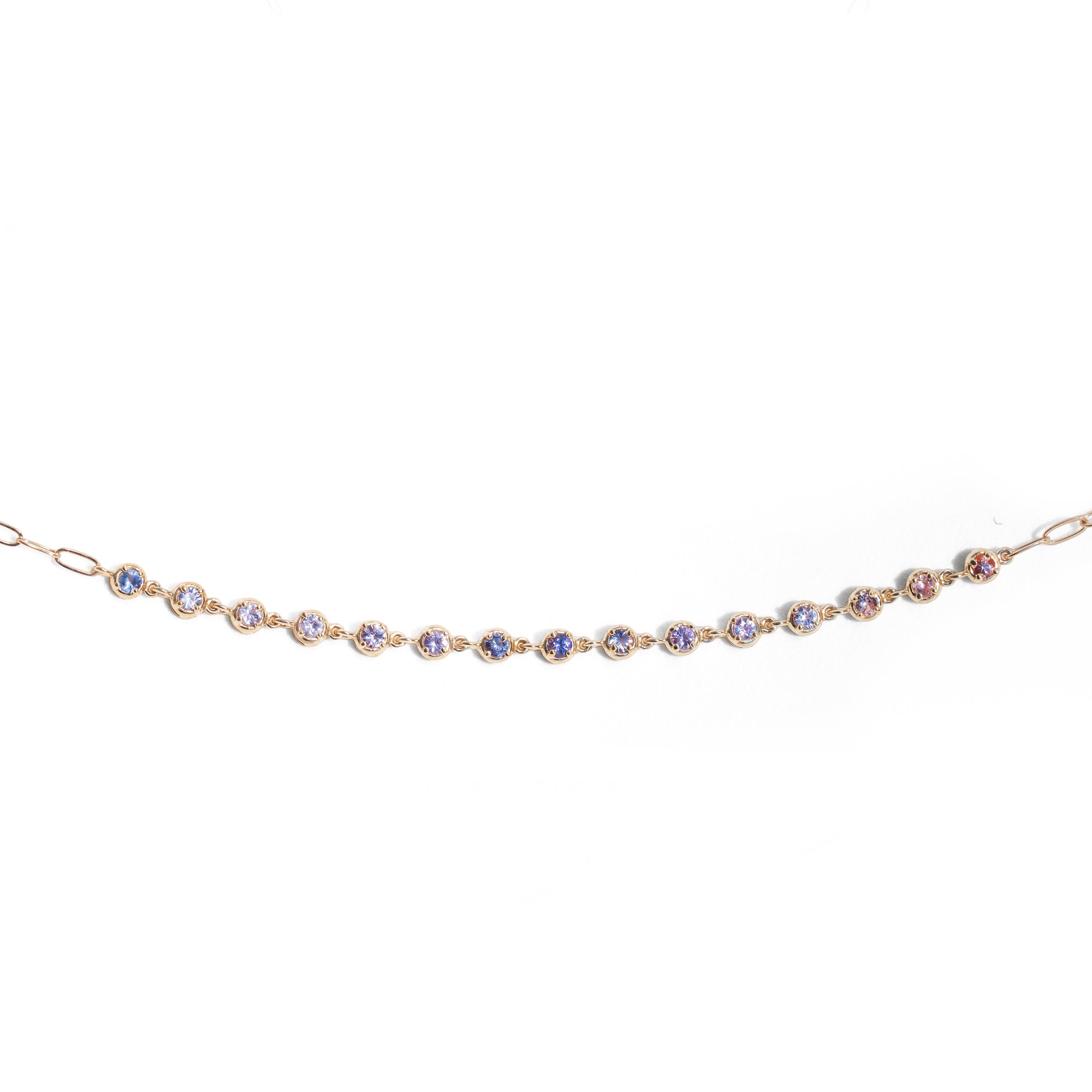 Gold bracelet with small colored sapphires on a white background