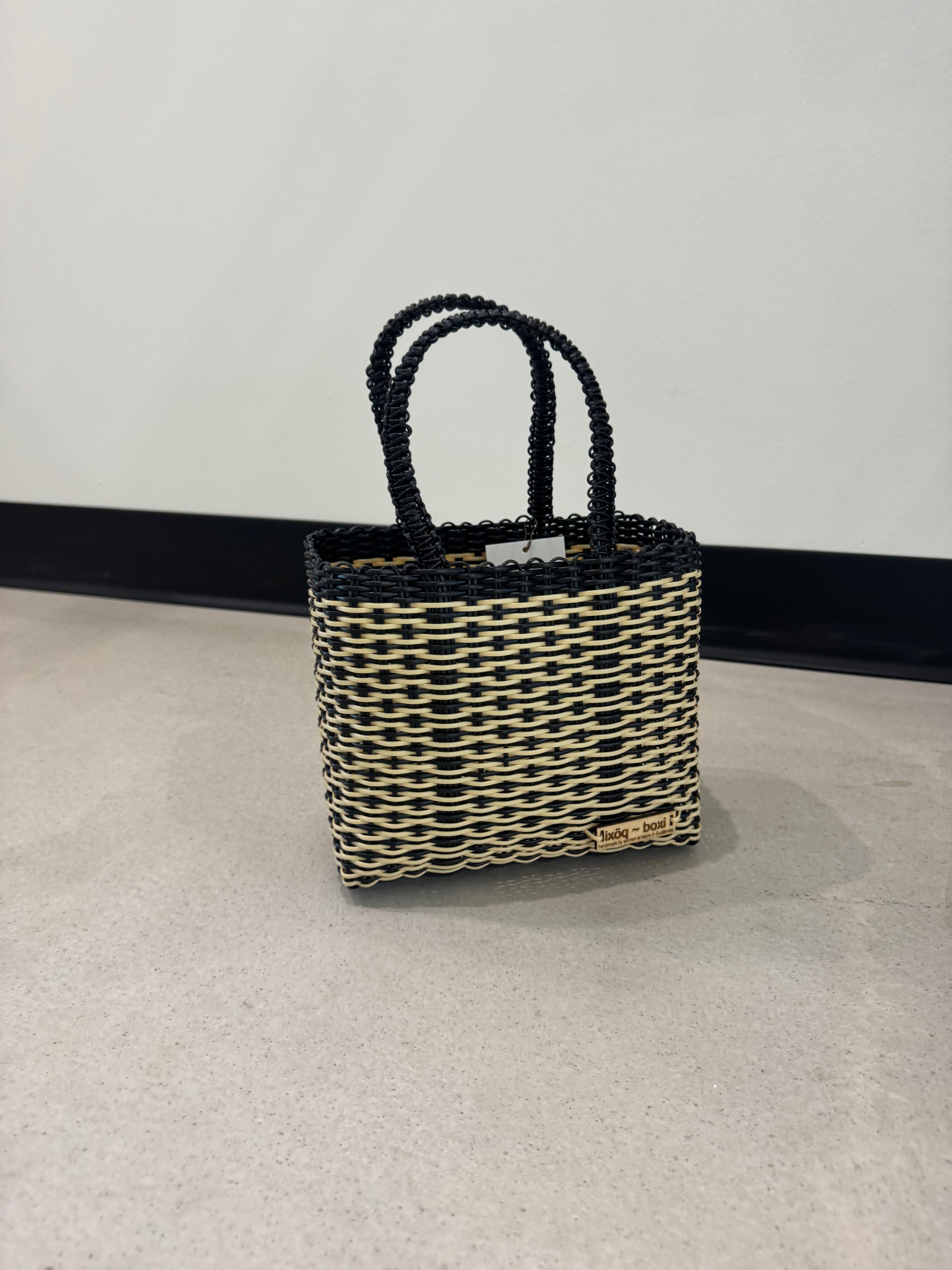 Woven handbag with a geometric pattern on a light gray background