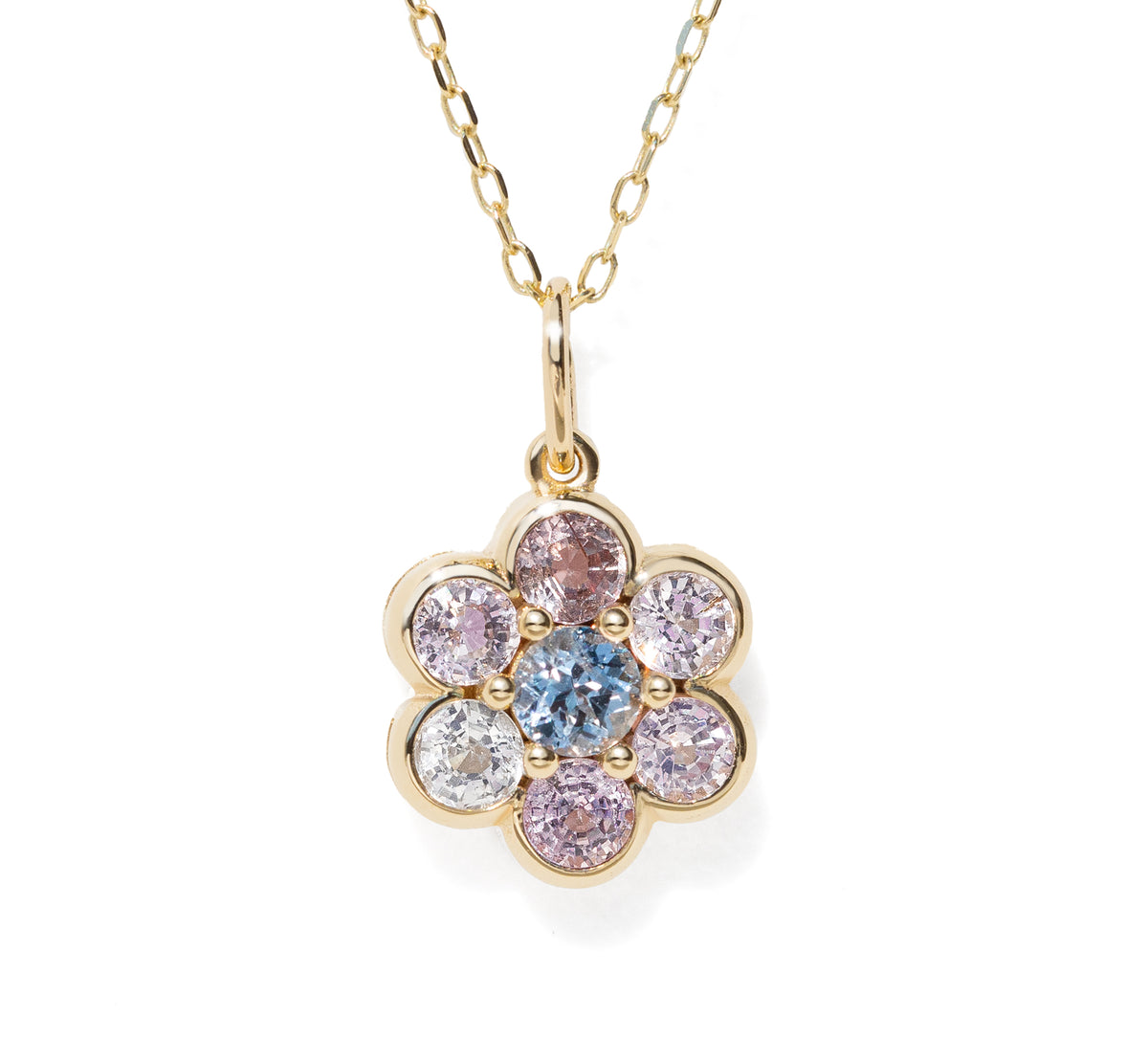 A gold flower-shaped pendant necklace featuring a central light blue round gemstone surrounded by six bezel-set round gemstones in pink, purple, and clear, suspended from a delicate gold chain on a white background.