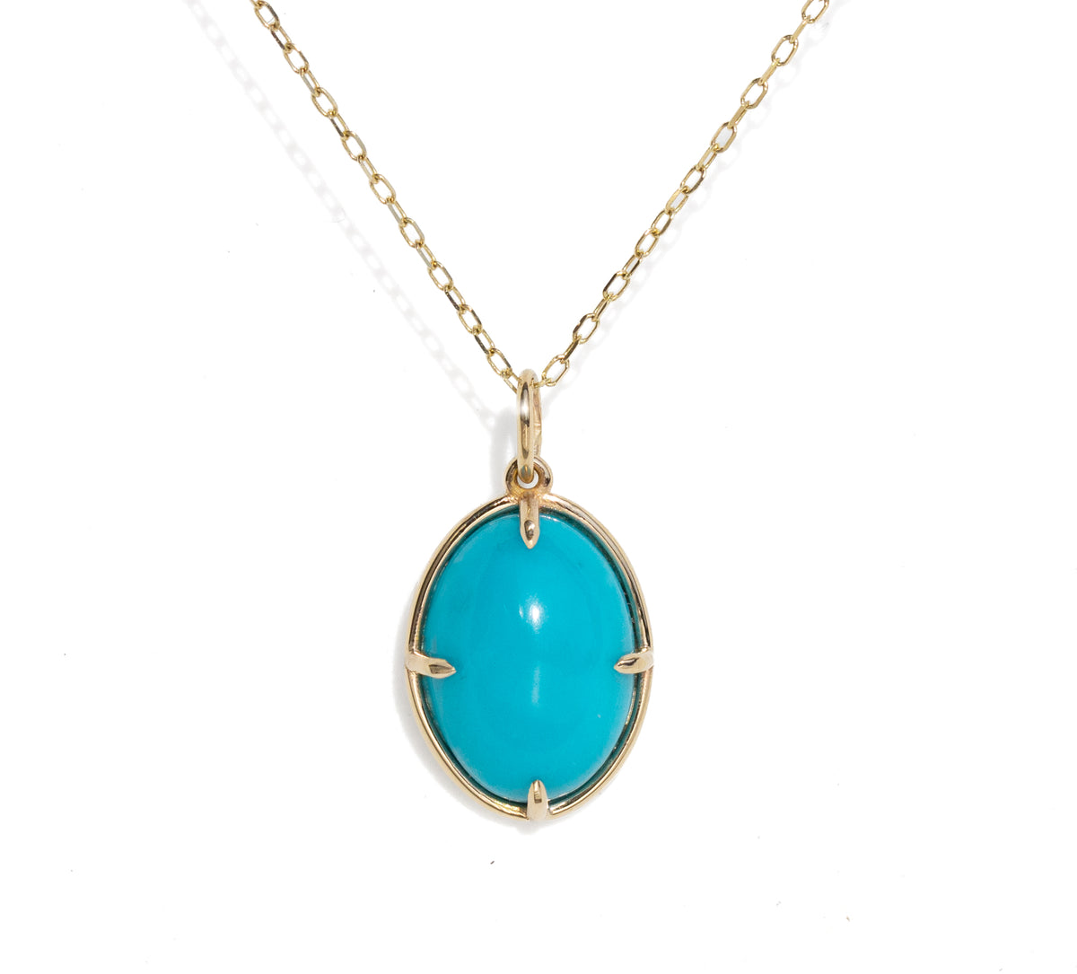 A gold chain necklace with an oval turquoise cabochon pendant in a gold bezel setting, shown against a plain white background.