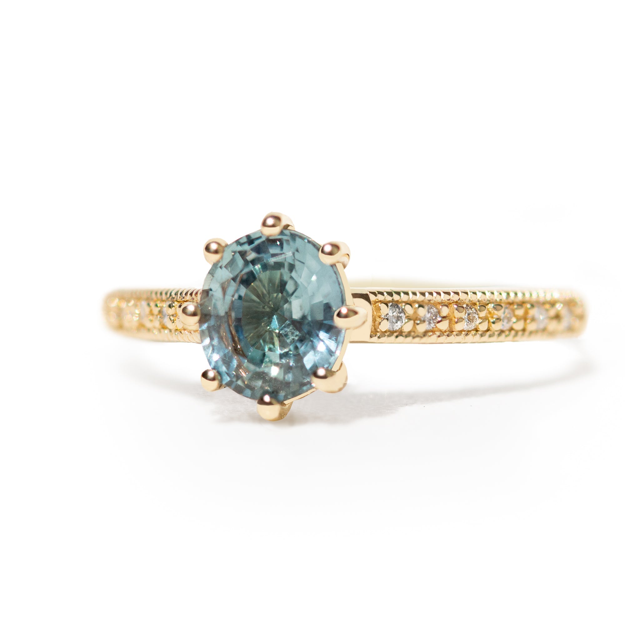 Gold ring with a blue gemstone on a white background