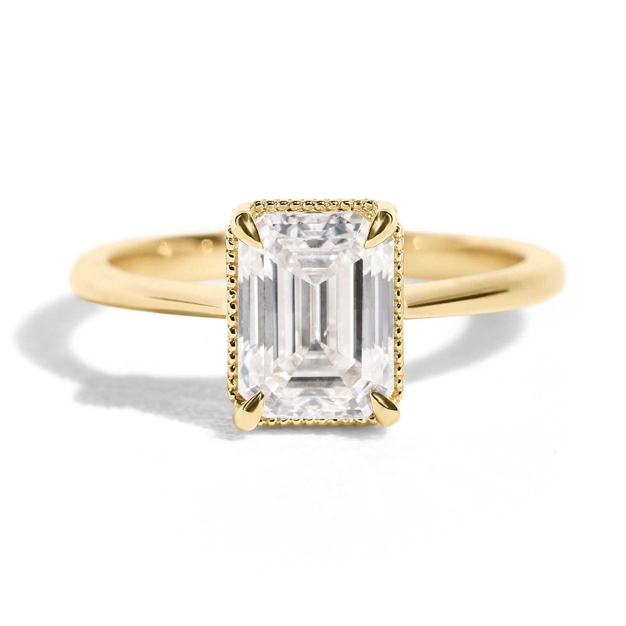The Hera Ring features a 1.5ct emerald cut diamond or moissanite set in a delicately milgrained setting. This elegant and romantic design effortlessly blends old-world charm with a modern aesthetic. It’s the perfect choice for engagements, milestone celebrations, birthdays, and anniversaries, making it a timeless piece.