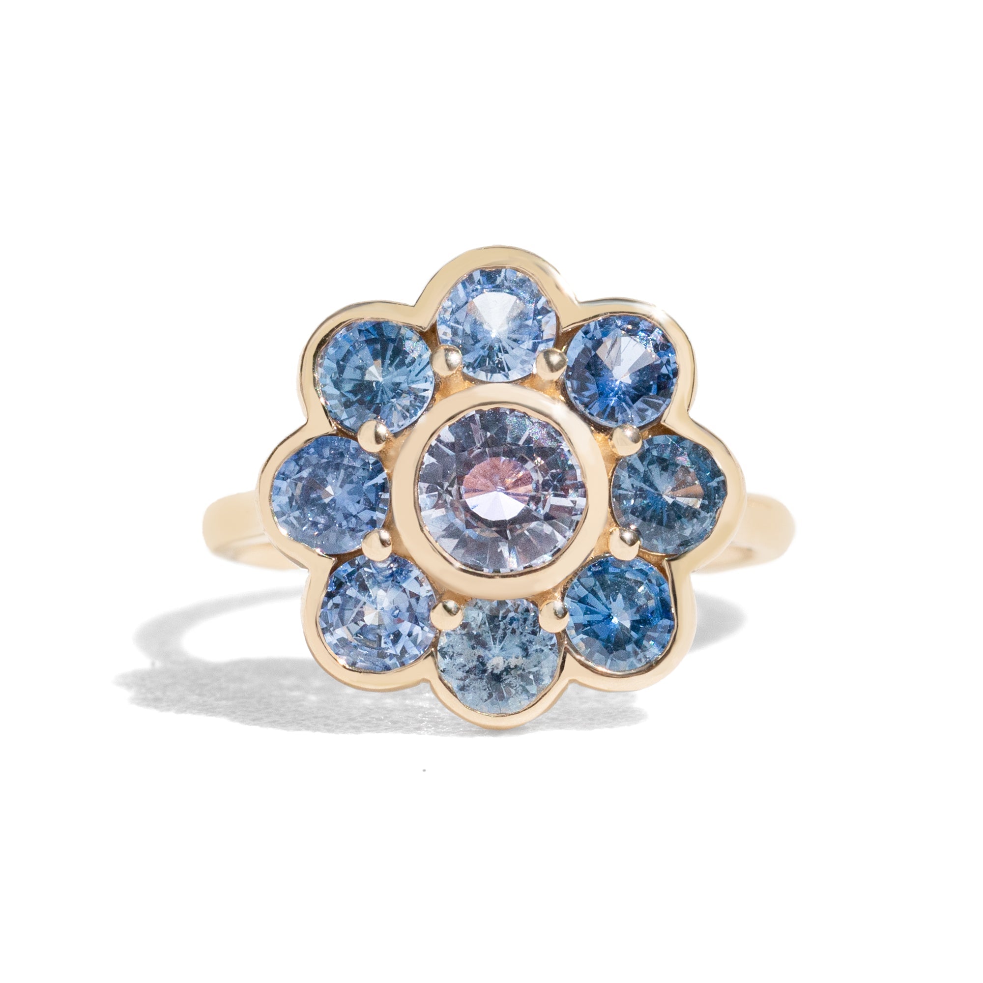 Gold ring with blue gemstones on a white background