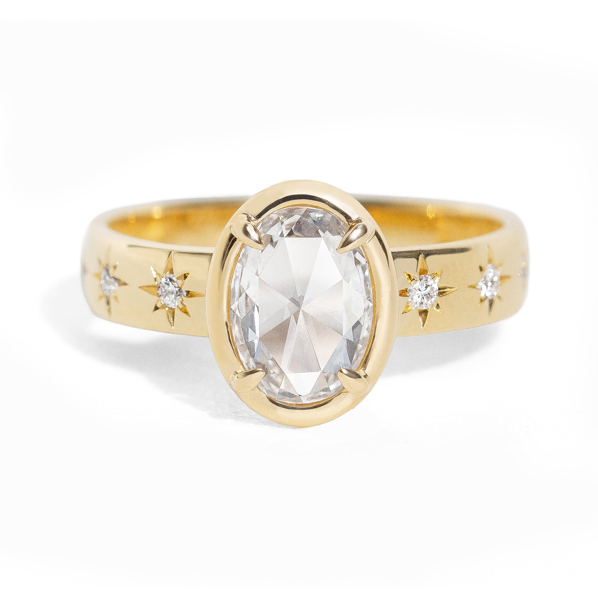Gold ring with a large oval rose cut diamond and smaller diamonds on the band against a white background