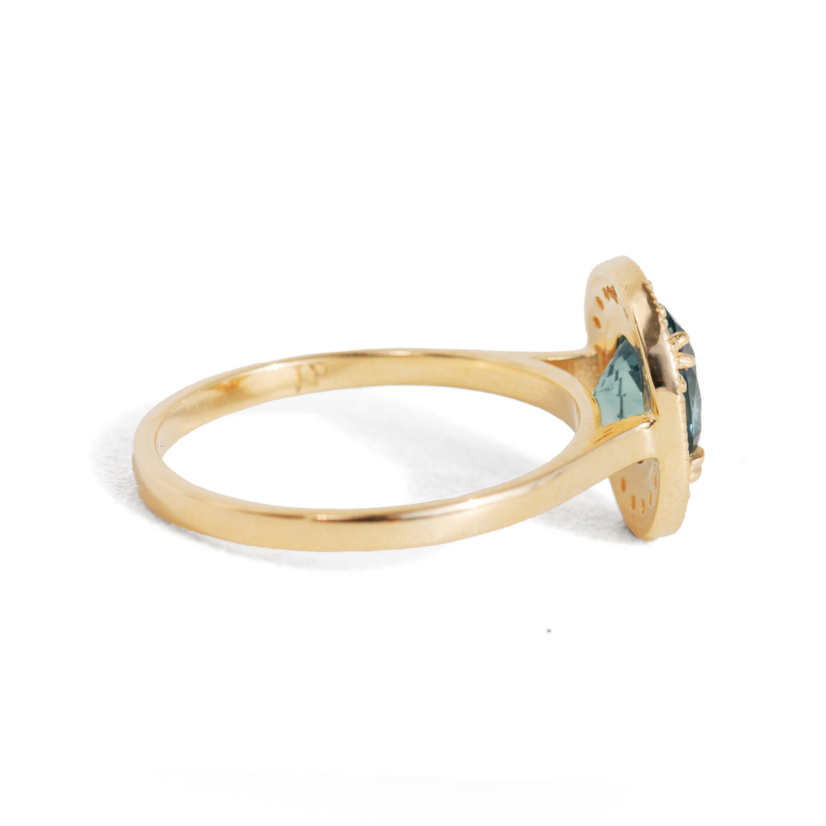 Gold ring with a green gemstone on a white background