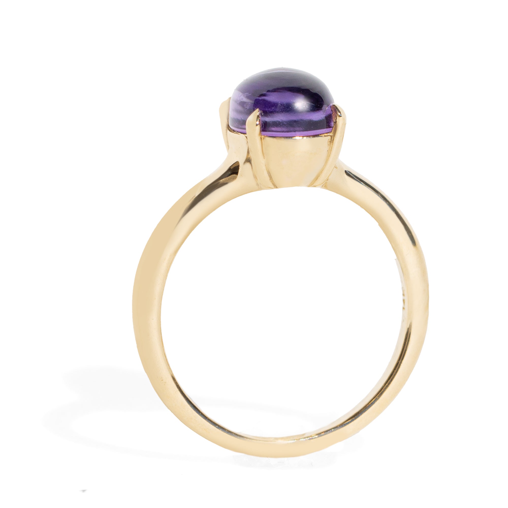 Gold ring with a purple gemstone on a white background