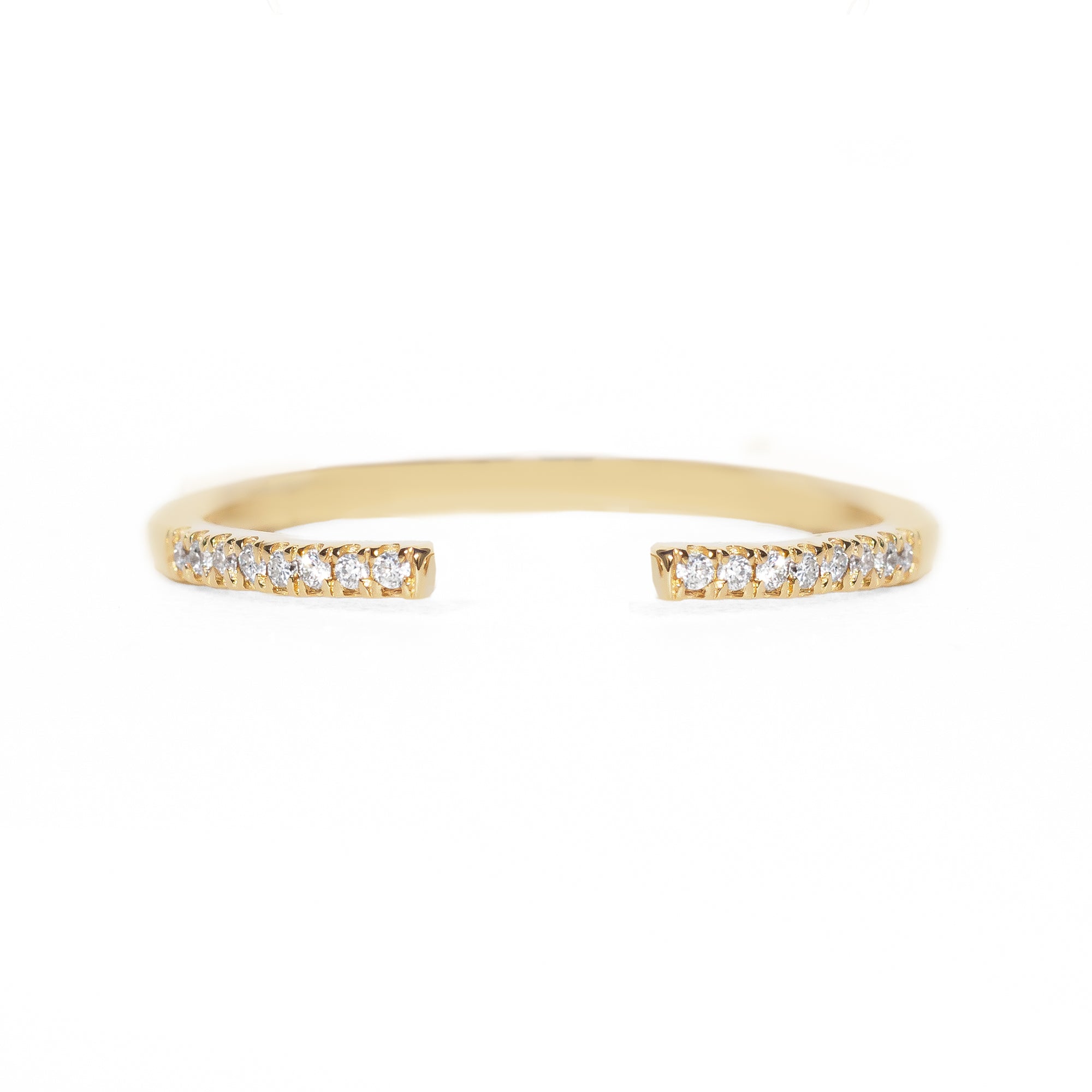 Open gold band with small diamonds on a white background