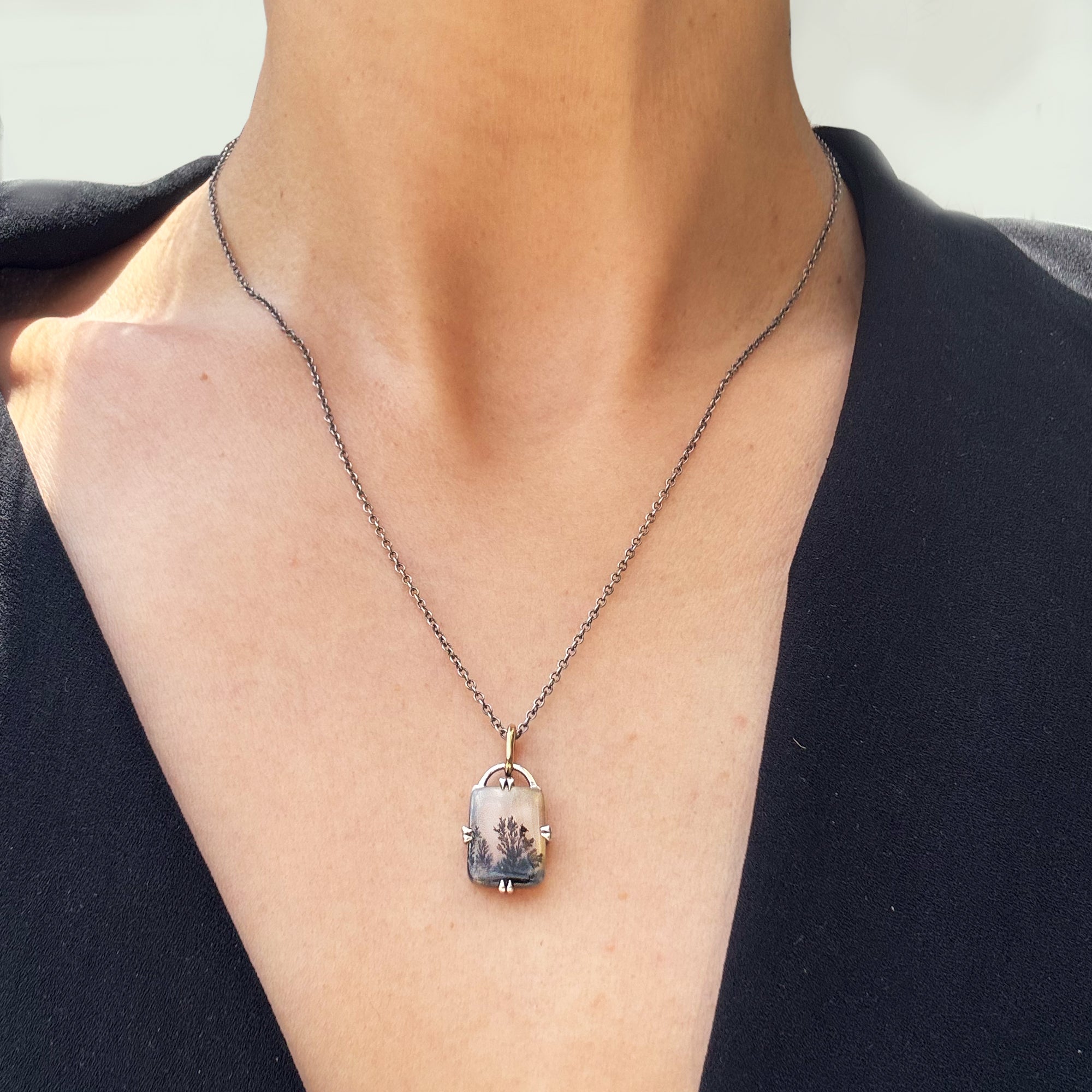A rectangular necklace worn on a woman