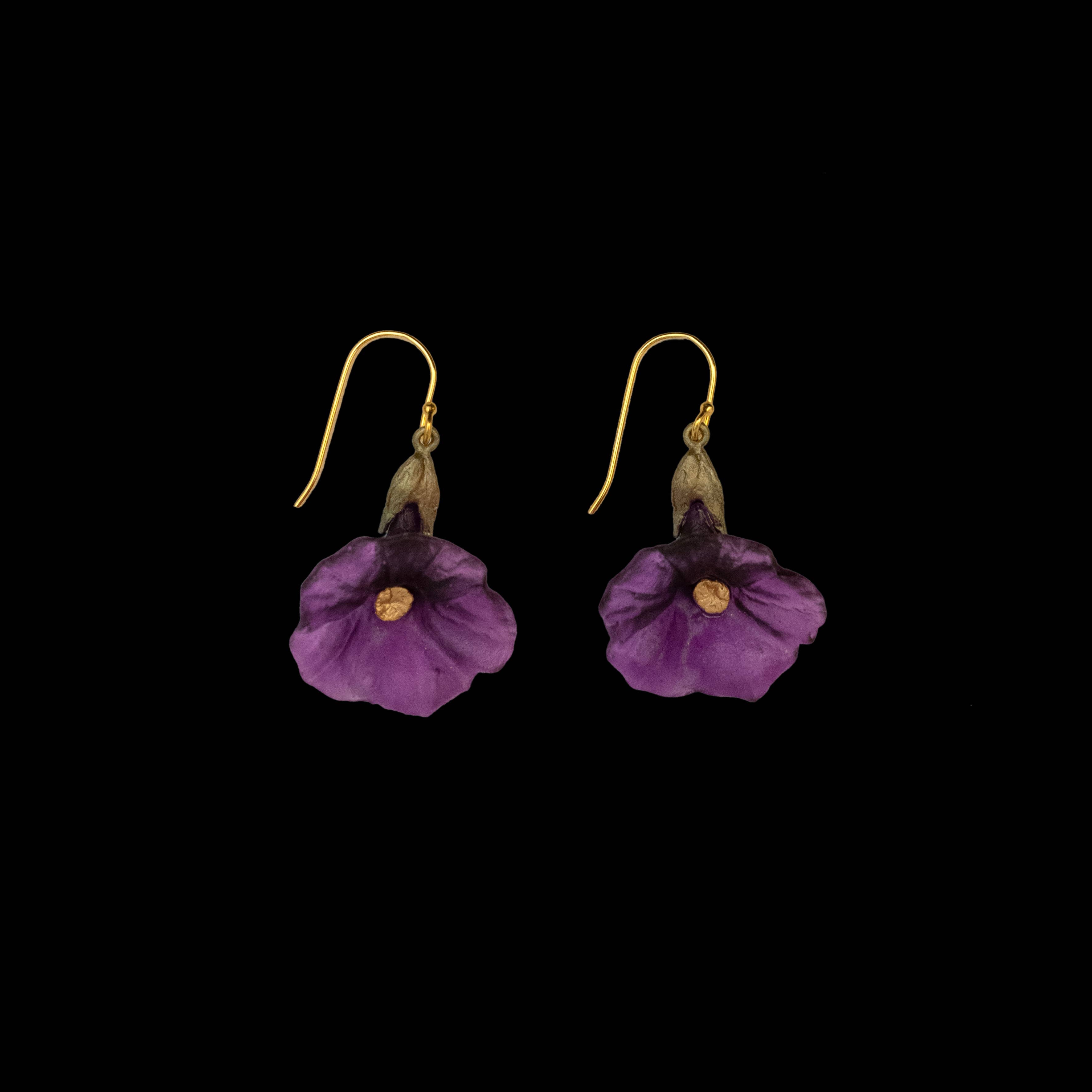 Purple flower-shaped earrings with gold accents on a black background
