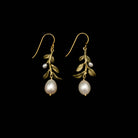 Pair of gold earrings with pearl drops on a black background