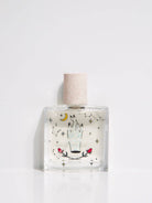 Clear bottle with decorative label and cork stopper on a white background