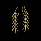 Pair of gold leaf-shaped earrings on a black background