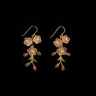 Floral earrings with pink flowers and green leaves on a black background