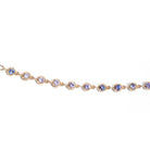 Gold bracelet with blue gemstones on a white background