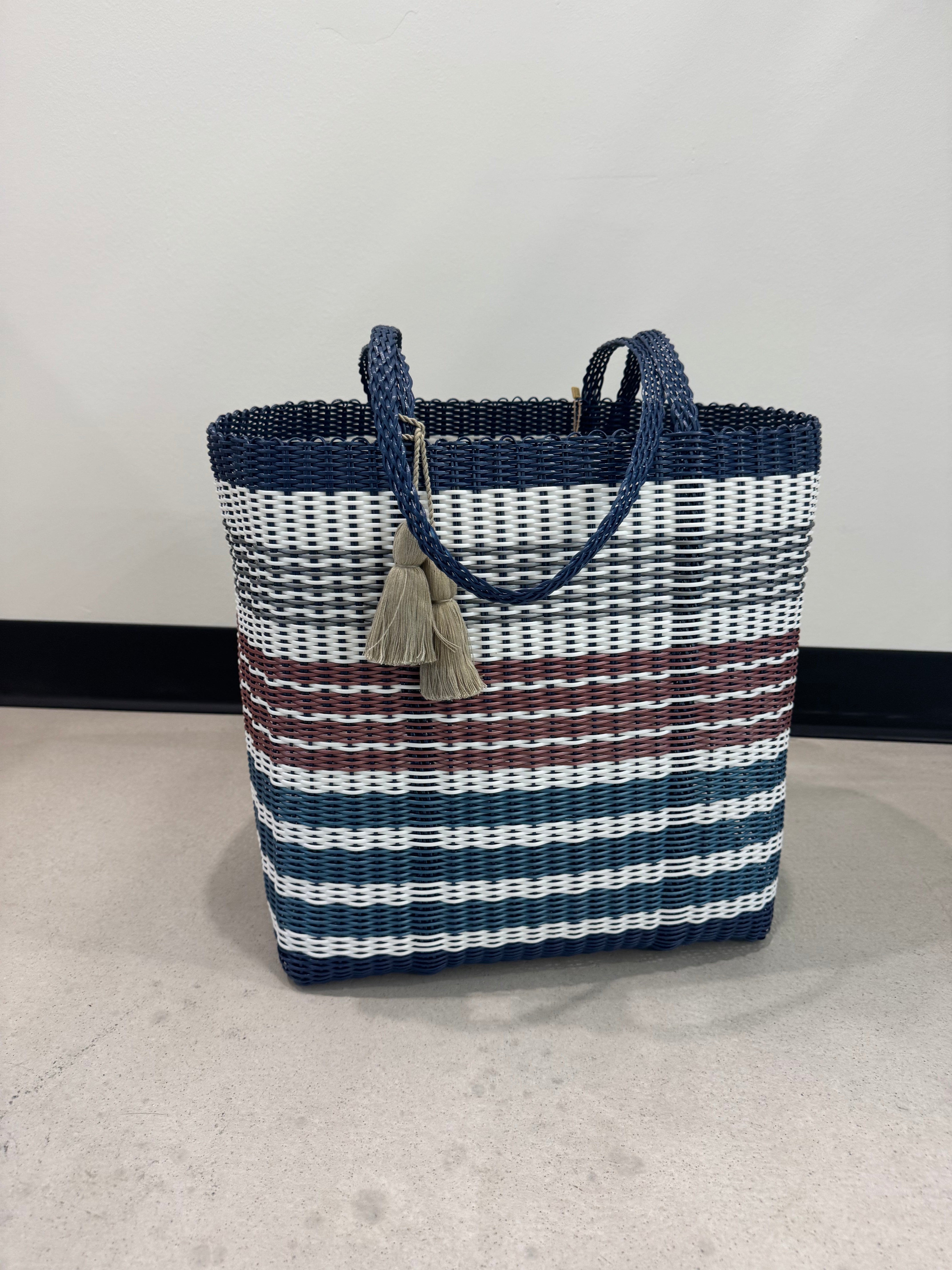 Woven handbag with blue, white, and brown pattern on a light gray background
