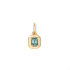 Gold necklace with a pendant featuring a blue green emerald cut sapphire on a white background