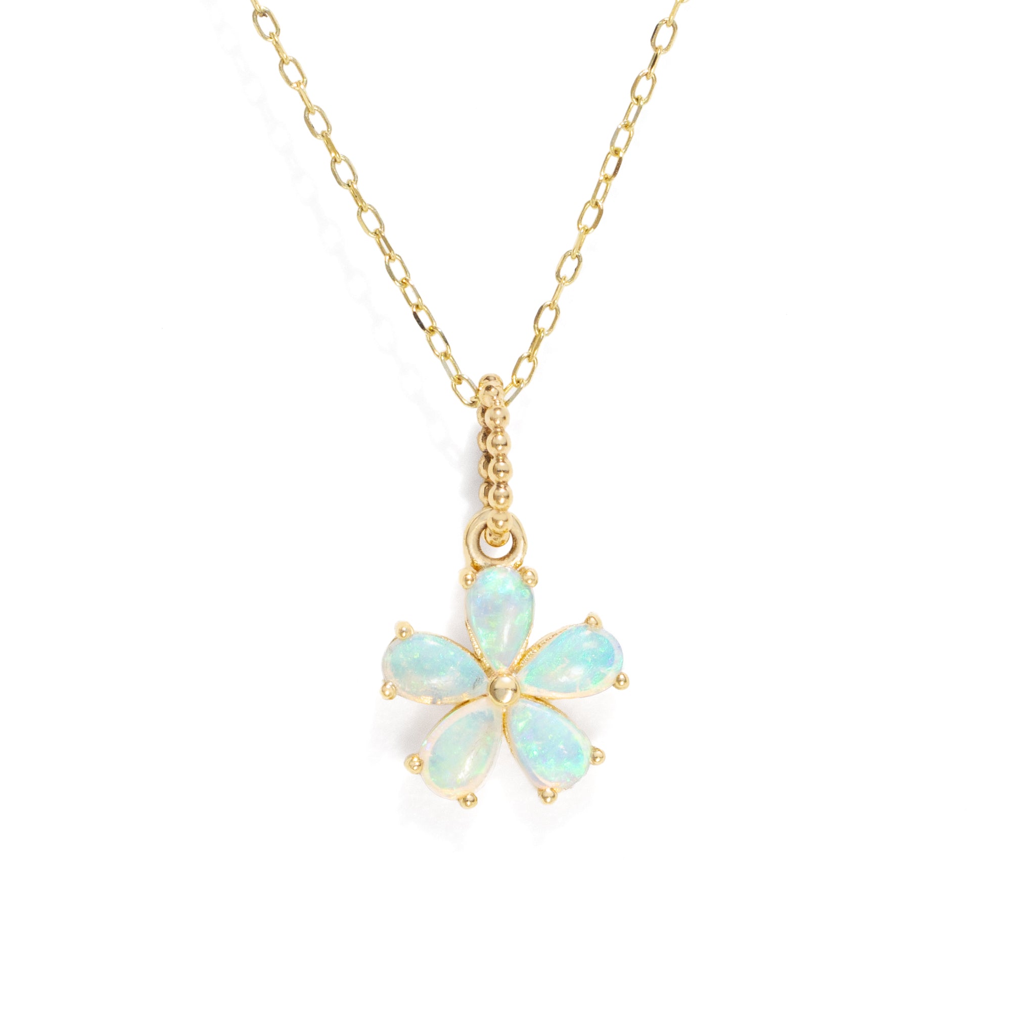 A floral shaped , five gemstone pendant necklace in gold color against a white background. 