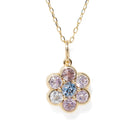 A gold flower-shaped pendant necklace featuring a central light blue round gemstone surrounded by six bezel-set round gemstones in pink, purple, and clear, suspended from a delicate gold chain on a white background.