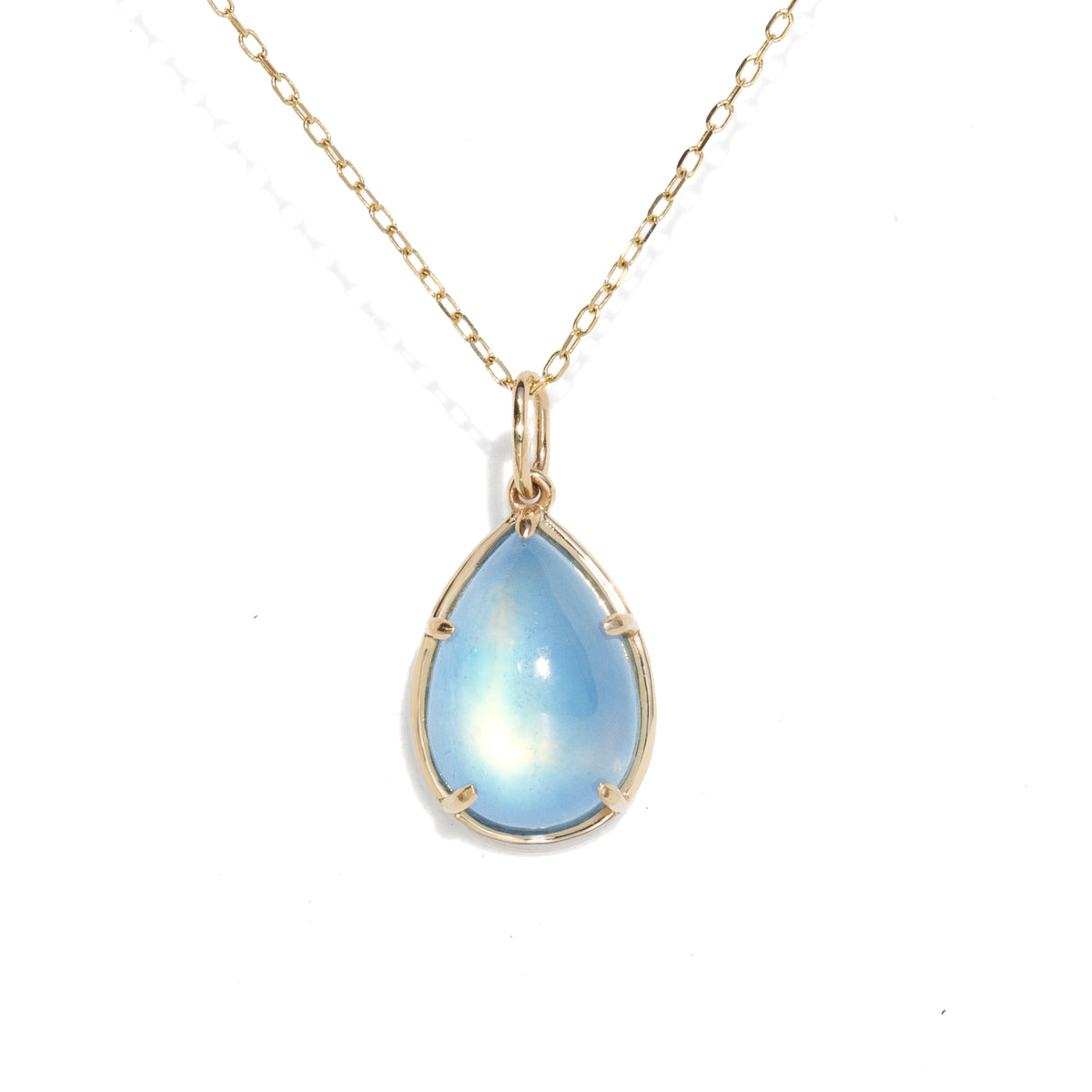 A gold teardrop pendant necklace featuring a light blue iridescent moonstone gemstone, suspended from a delicate gold chain on a white background.
