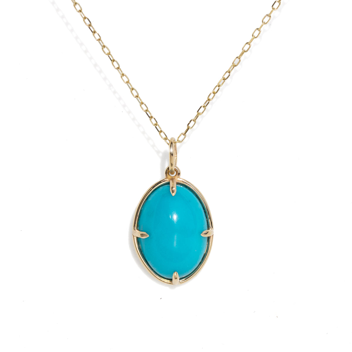 A gold chain necklace with an oval turquoise cabochon pendant in a gold bezel setting, shown against a plain white background.