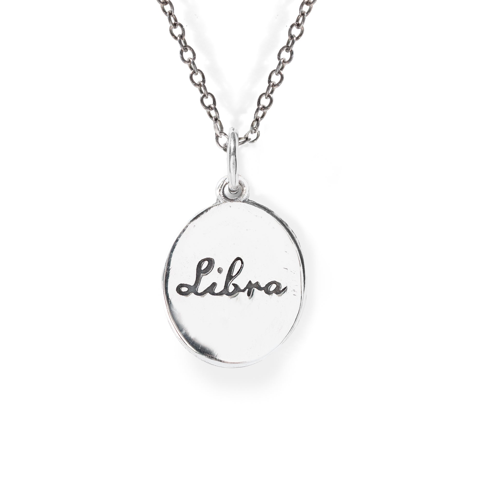 Silver necklace with a round pendant engraved with 'Libra' on a white background