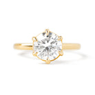 A gold solitaire ring with a round center diamond held by six prongs.