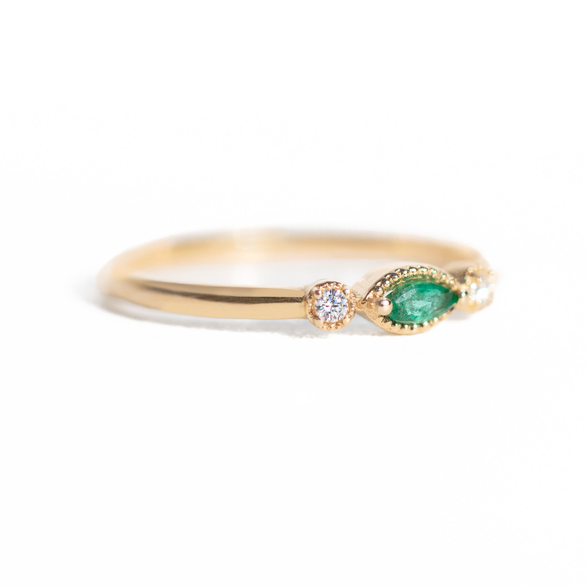 Made for vintage lovers, this Marquise Emerald Three Stone Ring features a bold green emerald in a marquise cut, complemented by sparkling diamonds on either side, all set in a beautiful milgrain setting. Its elegant yet understated design makes it ideal for everyday wear, a thoughtful gift, or as a delicate engagement ring.