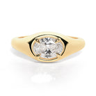 A gold band ring with an oval-shaped diamond set in an east-west orientation.