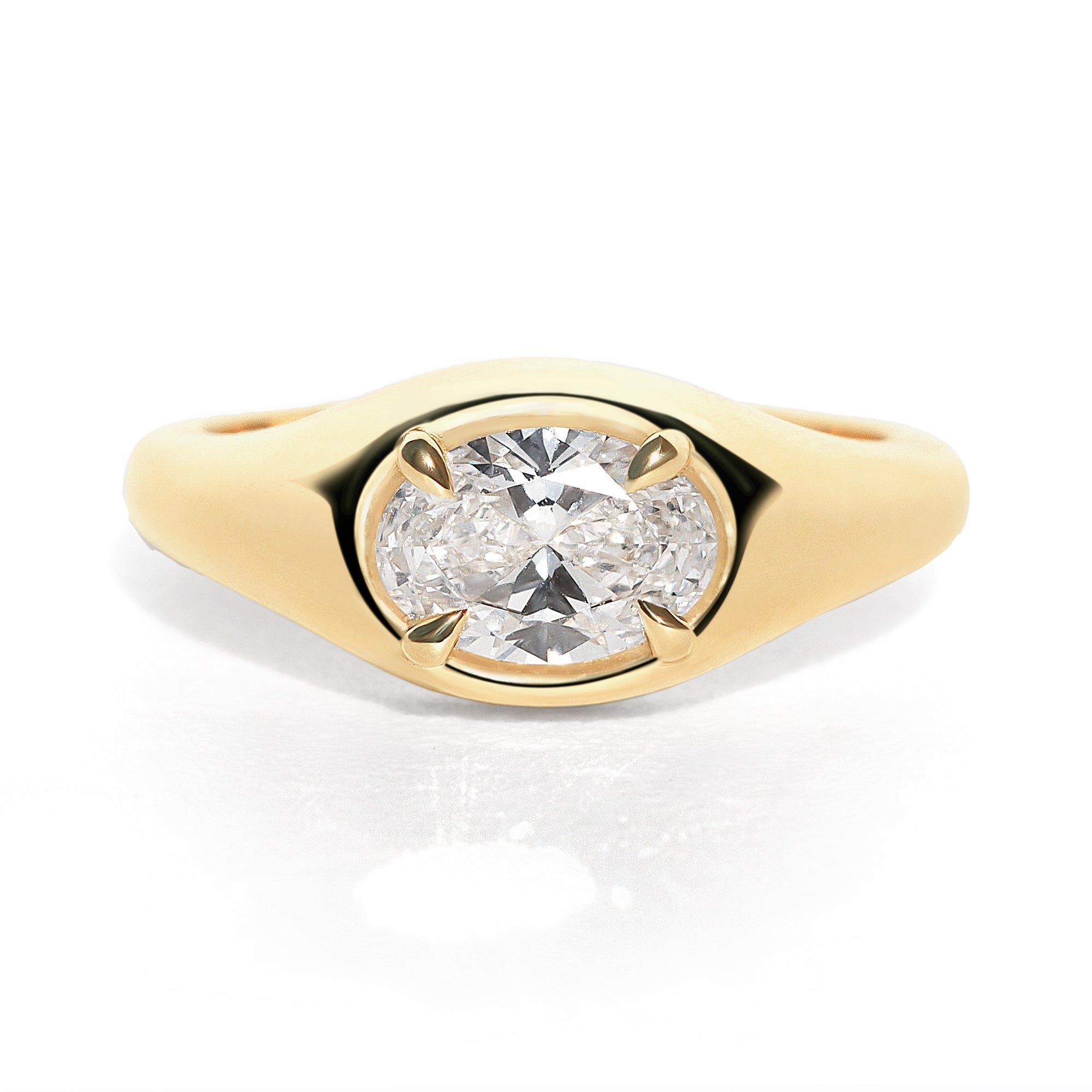 A gold band ring with an oval-shaped diamond set in an east-west orientation.
