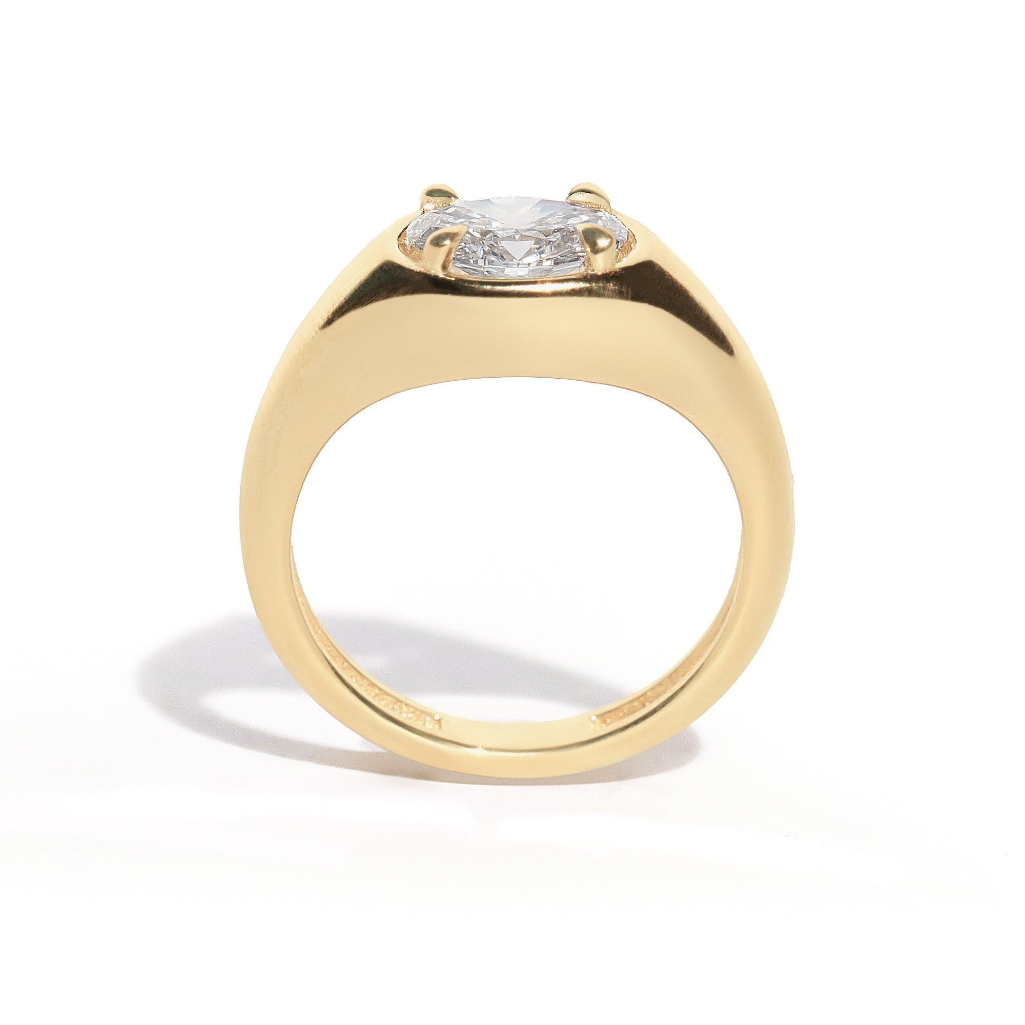 A gold band ring with an oval-shaped diamond set in an east-west orientation.