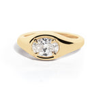 A gold band ring with an oval-shaped diamond set in an east-west orientation.