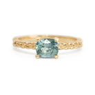 Jamie Park Jewelry -Meadow 1.16ct Cushion Montana Sapphire Ring Indulge in the beauty of nature with our Meadow Montana Sapphire Ring. Featuring a 1.16ct cushion cut sapphire, east-west set on an olive leaf band, this piece is perfect for an engagement ring or a special gift. The Montana sapphire's blue and green hues make it a truly one-of-a-kind piece to celebrate life's special moments.