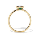 Gold ring with a green gemstone on a white background