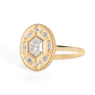 Gold ring with diamond accents around a hexagon diamond in the center on a white background