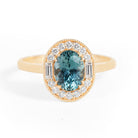 Gold ring with a blue gemstone and diamond accents on a white background