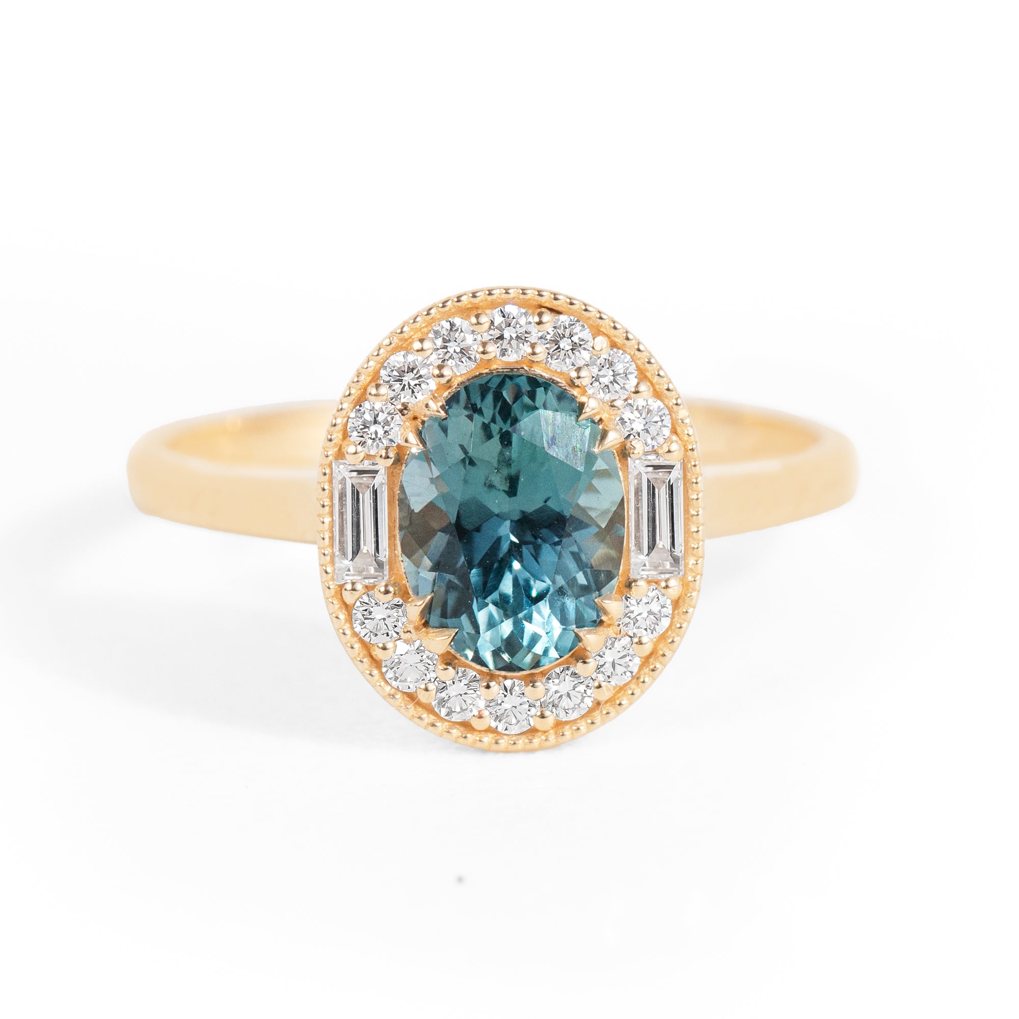 Gold ring with a blue gemstone and diamond accents on a white background
