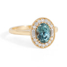 Gold ring with a blue gemstone and diamond accents on a white background