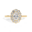 Gold ring with an oval diamond framed by small round halo diamonds on a white background