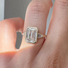 Diamond ring on a finger with a neutral background