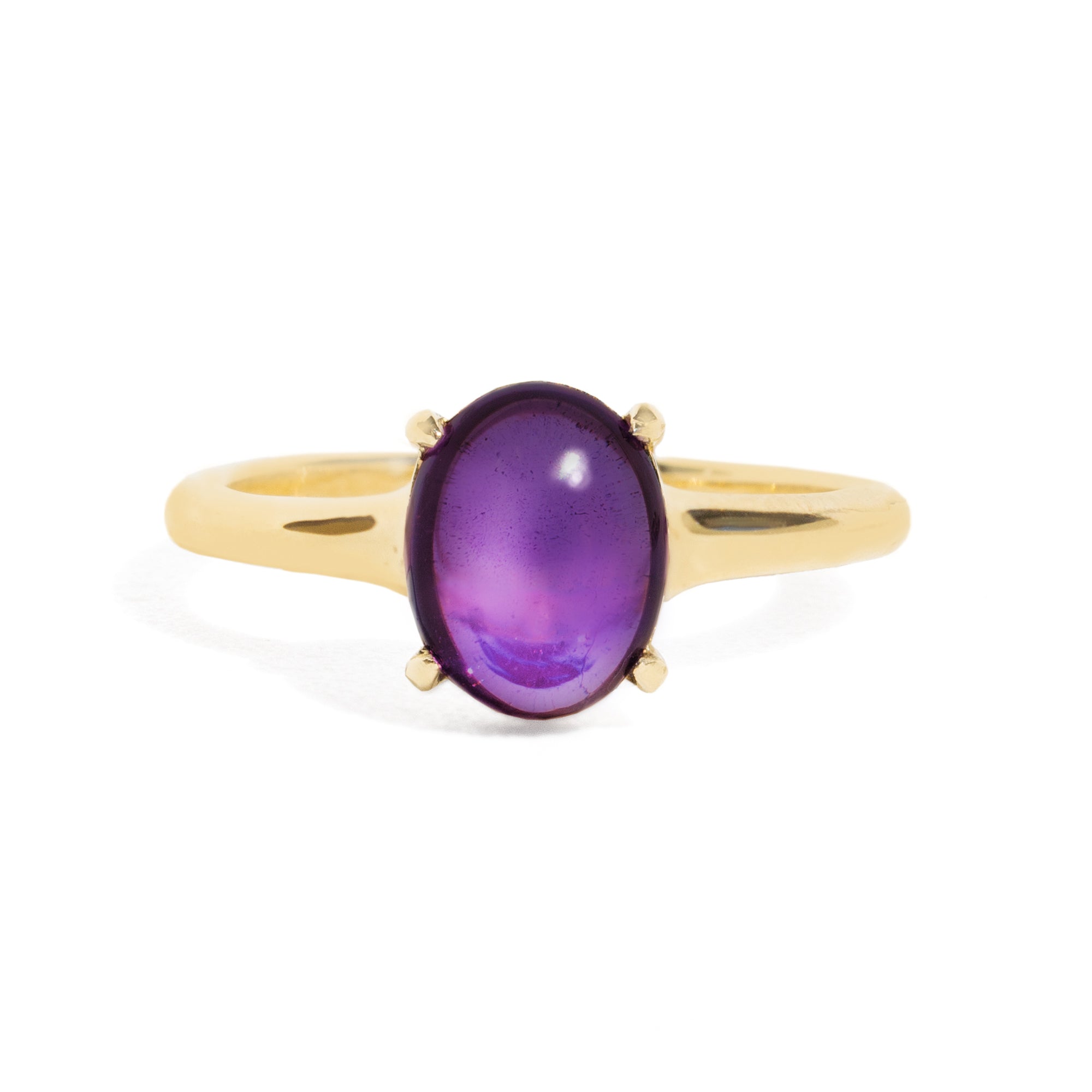 Gold ring with a purple gemstone on a white background