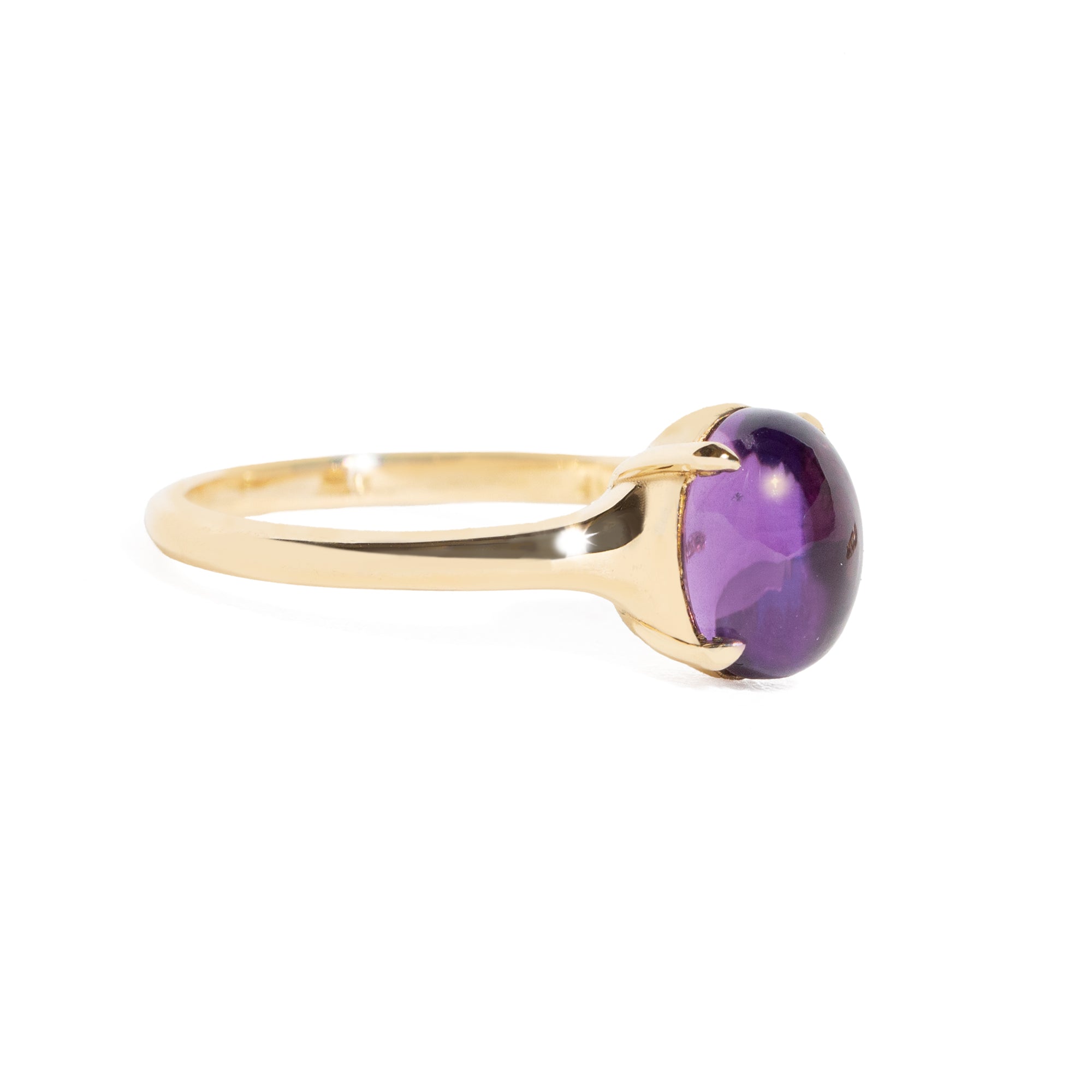 Gold ring with a purple gemstone on a white background
