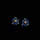 Blue flower earrings with gold accents on a black background