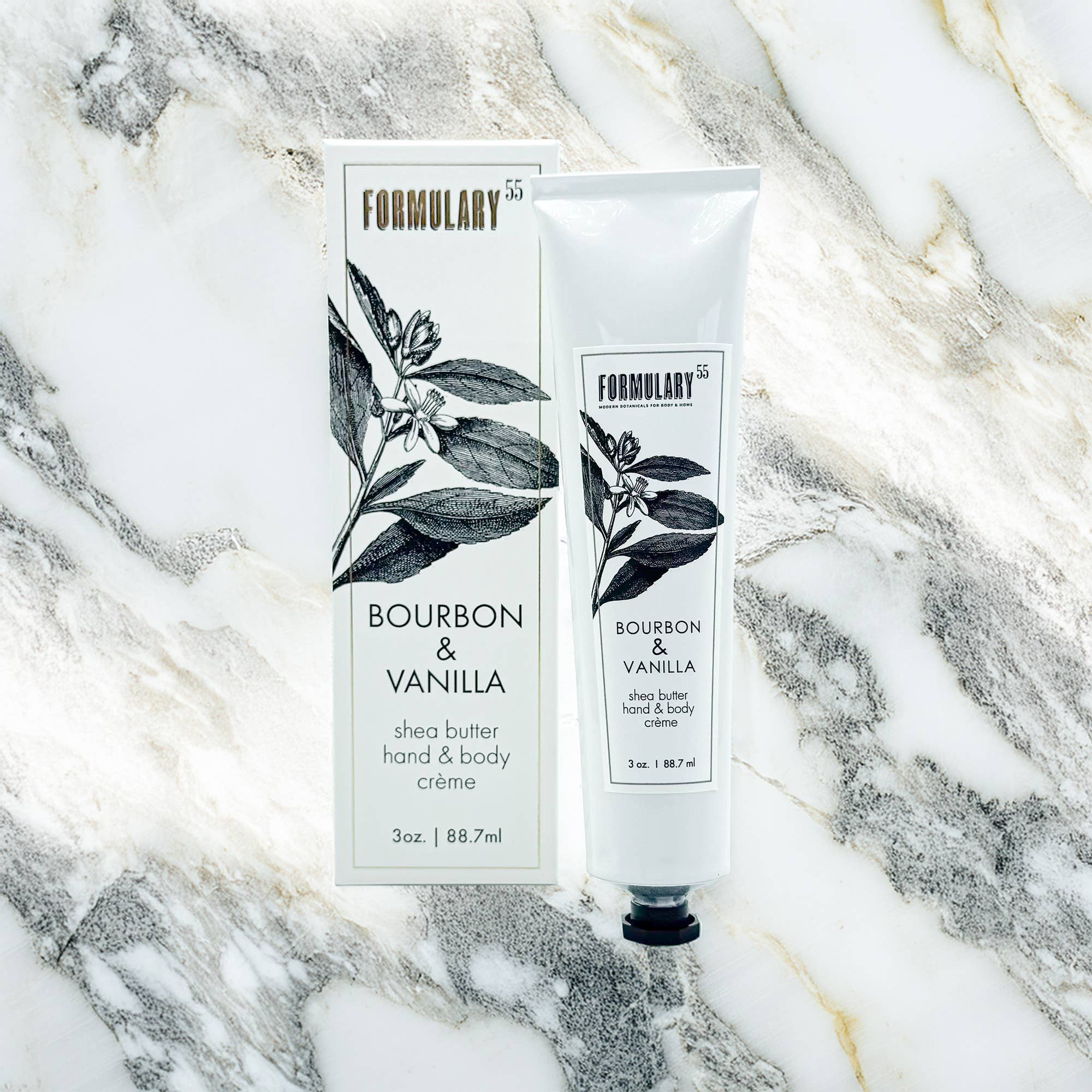 Shea butter hand and body crème with 'Bourbon & Vanilla' label on a marble background