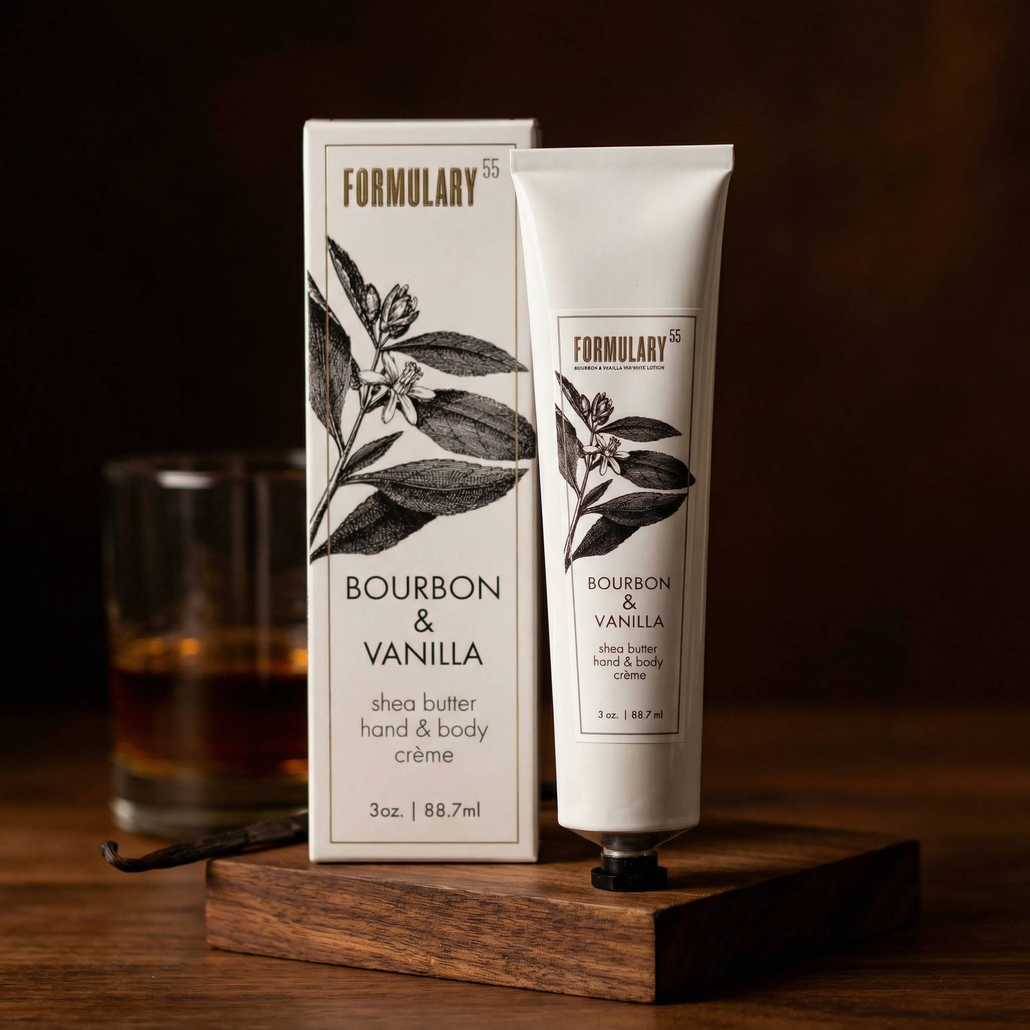Shea butter hand and body crème with packaging labeled 'Bourbon & Vanilla' by Formulary 55 on a wooden stand.