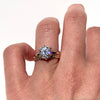 A gold solitaire ring with a round center diamond held by six prongs.