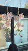 Flower earrings against a store window.