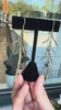 Leaf earrings against a storewindow