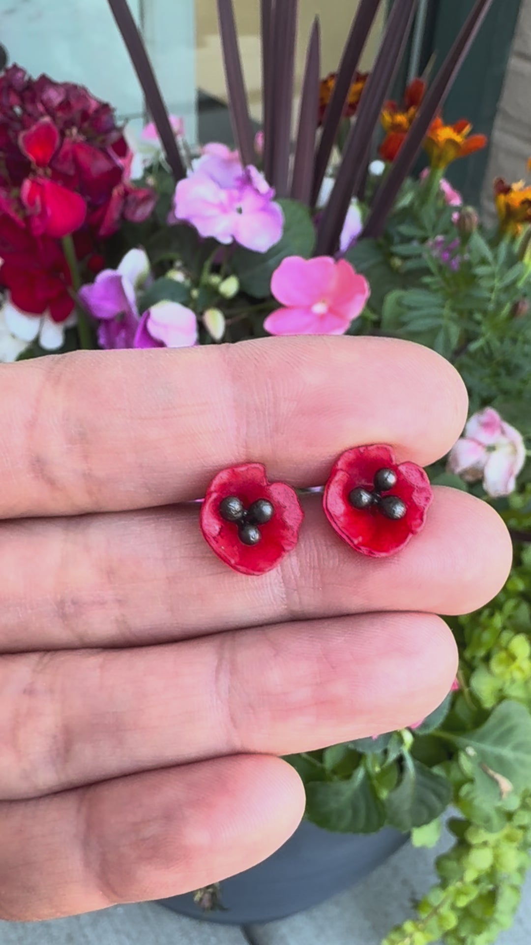 Poppy flower earrings against a floral background