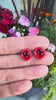 Poppy flower earrings against a floral background
