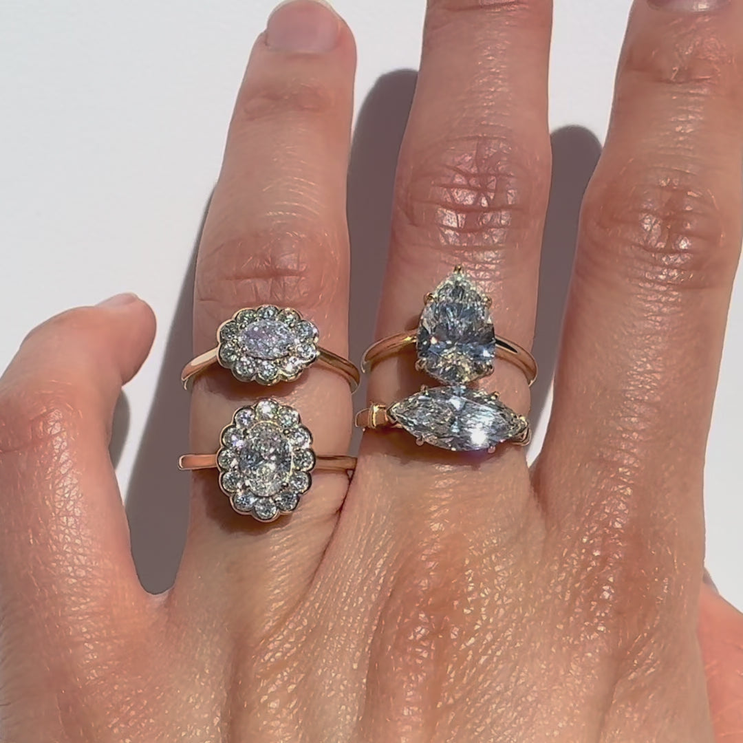 four diamonds ring on a hand against a white background